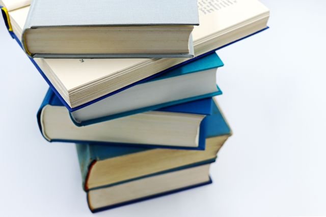 About Us A pile of books with blue covers on a white background, symbolizing education and knowledge.